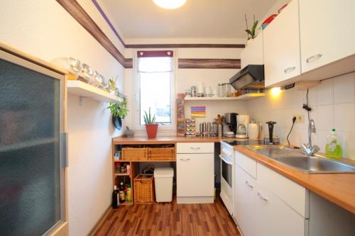 a small kitchen with white cabinets and a sink at Private Rooms in Hannover