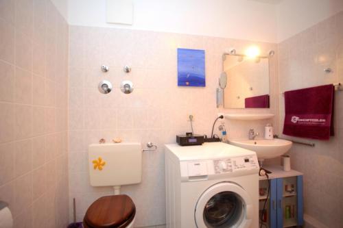y baño con lavadora y lavamanos. en Private Rooms, en Hannover