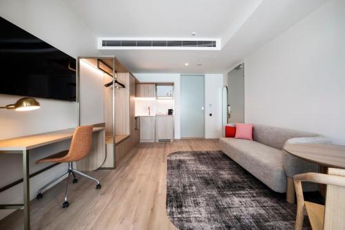 a living room with a couch and a desk at Holiday Inn & Suites Geelong by IHG in Geelong