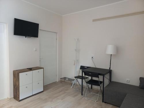a living room with a table and a tv on a wall at KOD VELIKIH TUJA in Melenci