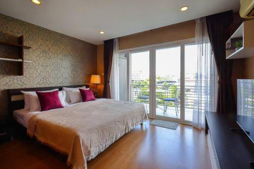 a bedroom with a large bed and a large window at Luxury Living in heart of Nimman in Chiang Mai