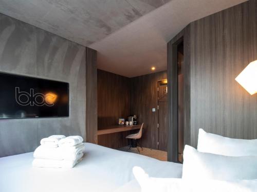 a hotel room with a bed with towels on it at Bloc Hotel London Gatwick Airport in Horley