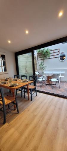 une salle à manger avec des tables et des chaises ainsi qu'une grande fenêtre dans l'établissement Maison de ville avec patio, à Trouville-sur-Mer