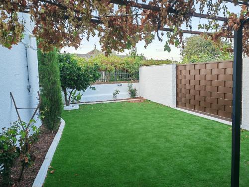 a backyard with green grass and a fence at Casa Rural Teralba 2 in La Calzada de Oropesa