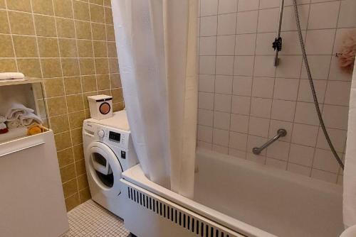 a bathroom with a washing machine next to a shower at Private Apartment in Hannover