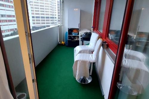 a room with a green floor and two chairs at Private Apartment in Hannover