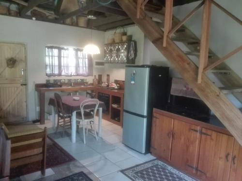 eine Küche mit einem Kühlschrank und einem Tisch mit Stühlen in der Unterkunft Emerald Hill Cottage in Mount Pleasant