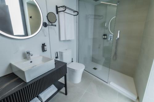 a white bathroom with a sink and a shower at HOTEL CORONA DE PADRÓN in Padrón
