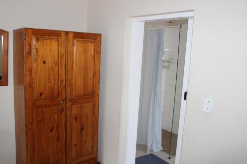 a bathroom with a wooden cabinet and a shower at Purple Olive Guest House in Pretoria