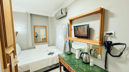 Habitación con cama y TV en la pared. en Taksim Centre Hotel, en Estambul
