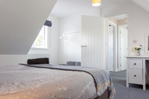 a white bedroom with a bed and a window at Stylish 4 Bed, newly renovated home in Nottingham in Nottingham
