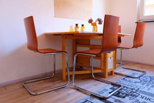 a table with two chairs and a table with bottles on it at Casa Colore with Garden and Courtyard in Wiesbaden