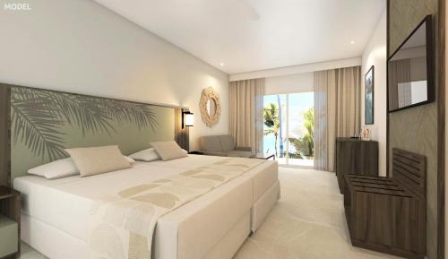 ein Schlafzimmer mit einem großen weißen Bett in einem Zimmer in der Unterkunft Riu Turquoise - All Inclusive in Le Morne
