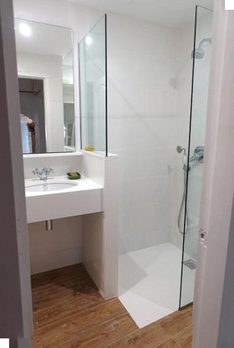 a white bathroom with a sink and a shower at Apartamento Palau Cadaques in Cadaqués