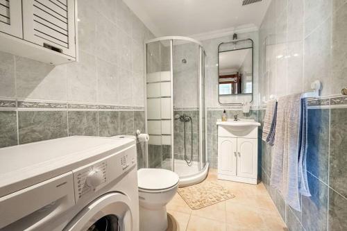 uma casa de banho com um WC e uma máquina de lavar roupa. em Ocean Frontline em Santa Cruz de Tenerife
