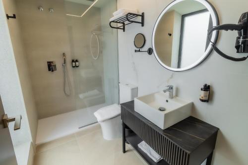 a white bathroom with a sink and a mirror at HOTEL CORONA DE PADRÓN in Padrón