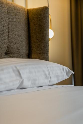 a close up of a bed with a pillow and a lamp at HOTEL CORONA DE PADRÓN in Padrón