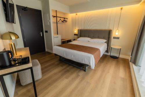 a hotel room with a large bed and a desk at HOTEL CORONA DE PADRÓN in Padrón