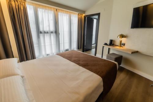 a hotel room with a large bed and a window at HOTEL CORONA DE PADRÓN in Padrón