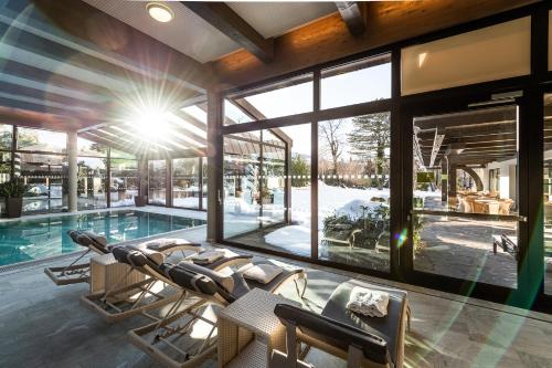 uma casa com piscina e um monte de cadeiras em Park Igls - Medical Spa Resort em Innsbruck