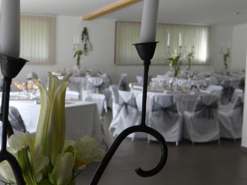 a room with white tables and white candles and flowers at Domaine Du Val De Cèze in Bagnols-sur-Cèze