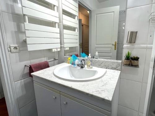 une salle de bain blanche avec un lavabo et un miroir dans l'établissement l'appartement Malesherbes, à Paris