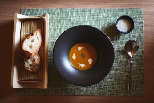 une assiette de pain et un bol de soupe sur une table dans l'établissement 結びの小宿 縁, à Kobe