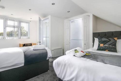 twee bedden in een kamer met witte muren en ramen bij SCA-Big House 9min to NEC - Sleeps 7 - Park 3 vans in Birmingham