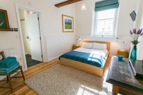 a small bedroom with a bed and a window at Cribinau in Aberffraw