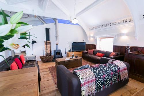 a living room with two couches and a tv at Cwyfan in Aberffraw