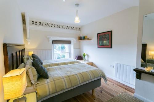 a bedroom with a bed and a window at Cwyfan in Aberffraw