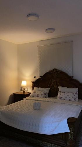 a bedroom with a large bed with a wooden headboard at جاذر إن in Ad Dawādimī