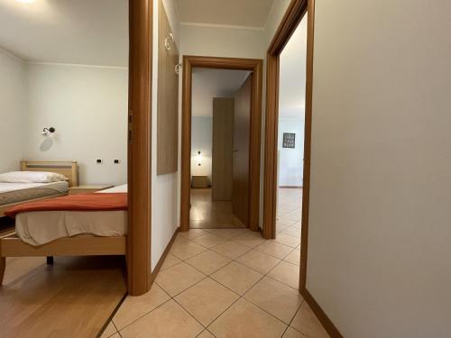 a bedroom with a bed and a hallway at Residence Valentino in Pinzolo