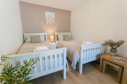 a bedroom with two beds and a table at Cil Haul in Llanfaelog
