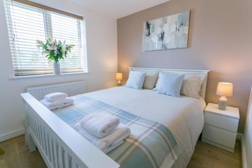 a bedroom with a white bed with towels on it at Cil Haul in Llanfaelog