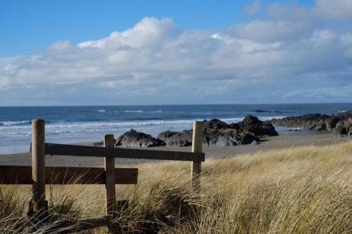 a bench sitting on the beach near the ocean at Cil Haul in Llanfaelog