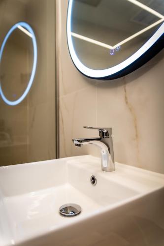 a bathroom sink with a mirror and a faucet at HOTEL CORONA DE PADRÓN in Padrón