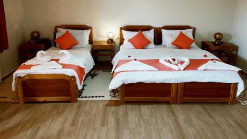 a bedroom with two beds with towels on them at Hotel Meteorites Boulaajoul in Zaida