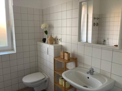 uma casa de banho com um lavatório, um WC e um espelho. em Wohnung im Grünen 