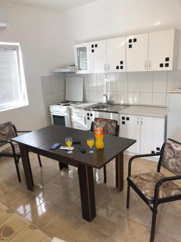 a kitchen with a table with two glasses on it at Ninkovic Apartman Free Parking in Kaluđerica