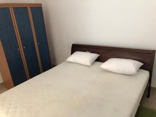 a bedroom with a bed with two pillows on it at Ninkovic Apartman Free Parking in Kaluđerica