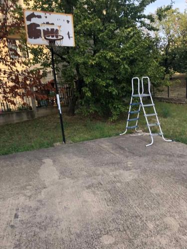 a basketball hoop with a ladder next to a sign at Ninkovic Apartman Free Parking in Kaluđerica