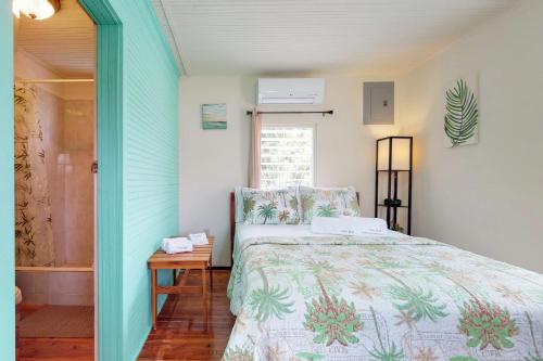 una camera da letto con un letto, un tavolo e una finestra di Casa DV Cabanas Gold Standard Certified a Caye Caulker