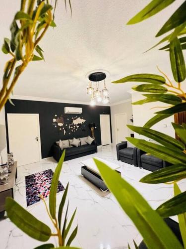 ein Wohnzimmer mit Sofa und einigen Pflanzen in der Unterkunft Luxury 4-bedrooms apartment in Aqaba