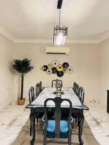a dining room with a black table and chairs at Luxury 4-bedrooms apartment in Aqaba