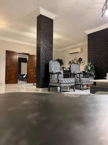 a living room with two chairs and a pillar at Luxury 4-bedrooms apartment in Aqaba