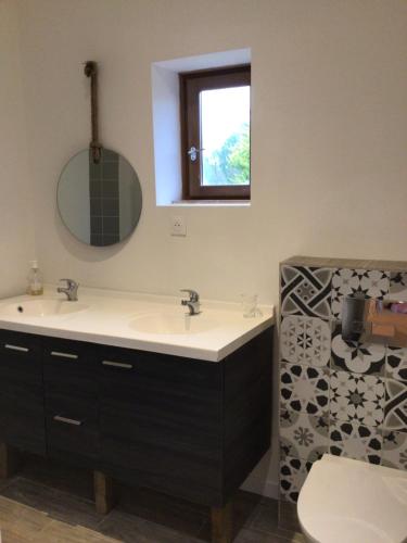 ein Badezimmer mit einem Waschbecken, einem WC und einem Spiegel in der Unterkunft Grande maison, calme, proche de la mer in Camoël
