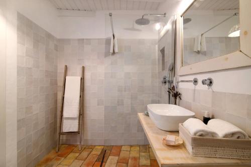 bagno bianco con lavandino e specchio di Casa de Benafim 51 a Benafim