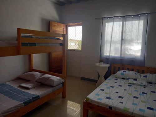 a bedroom with two bunk beds and a window at COSTA DE ANGELO BOLO BEACH RESORT in Alaminos
