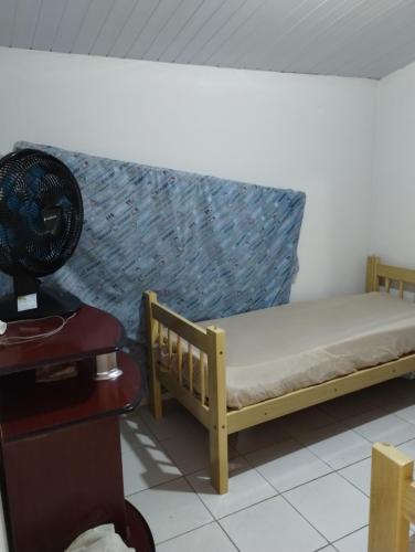 um pequeno quarto com uma cama e uma ventoinha em Casa em Tamandaré a 1km de Carneiros no Condomínio Cote d' Azur em Tamandaré